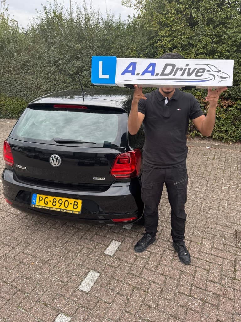 Andreas, geslaagd bij A.A.Drive met het dakbord van de lesauto